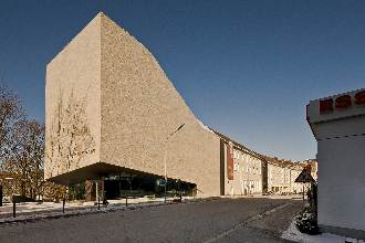 Die moderne Natursteinfassade des Sudetendeutschen Museums München bei Tag.